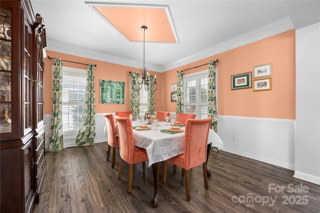 dining room featuring an inviting chandelier, ornamental molding, dark wood-style floors, and wainscoting