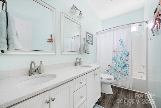 full bathroom with a sink, toilet, wood finished floors, and double vanity