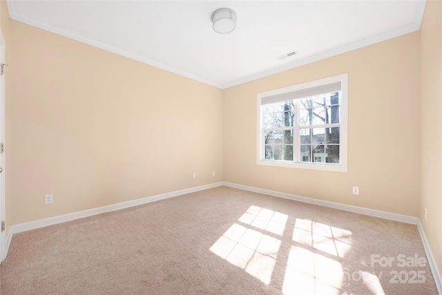 spare room with visible vents, light colored carpet, baseboards, and ornamental molding