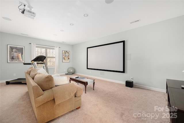 carpeted cinema room featuring visible vents and baseboards