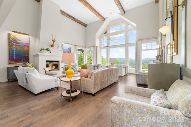 68 Cinch Knot Dr, Nebo, NC 28761 - living room with healthy amount of natural light, a high ceiling, beam ceiling, wood finished floors, and a warm lit fireplace