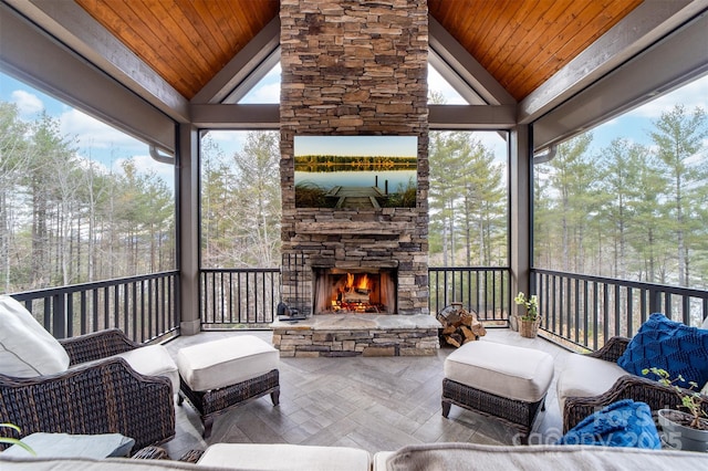 68 Cinch Knot Dr, Nebo, NC 28761 - sunroom featuring lofted ceiling, an outdoor living space with a fireplace, healthy amount of natural light, and view of scattered trees