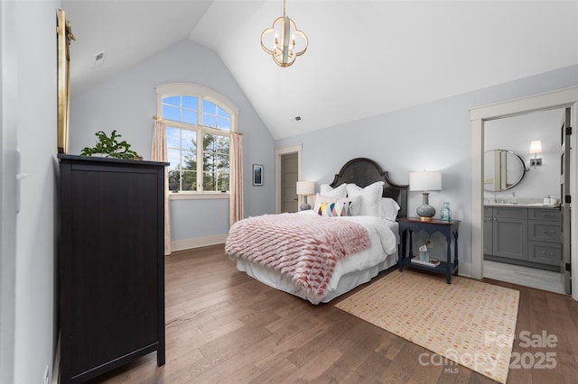68 Cinch Knot Dr, Nebo, NC 28761 - bedroom with lofted ceiling, wood finished floors, a chandelier, baseboards, and connected bathroom