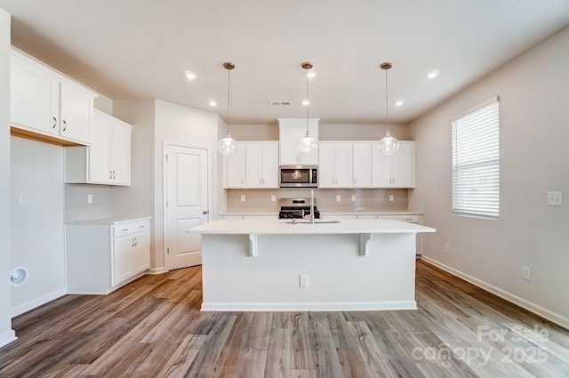 kitchen with visible vents, light wood-type flooring, light countertops, appliances with stainless steel finishes, and a sink