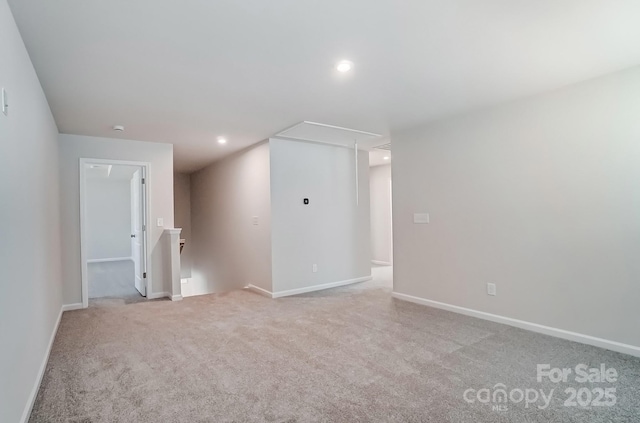 unfurnished room featuring light carpet, recessed lighting, attic access, and baseboards