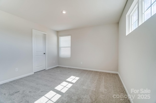 carpeted spare room featuring recessed lighting and baseboards