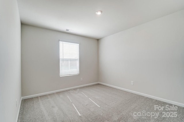 empty room with baseboards, visible vents, and carpet floors