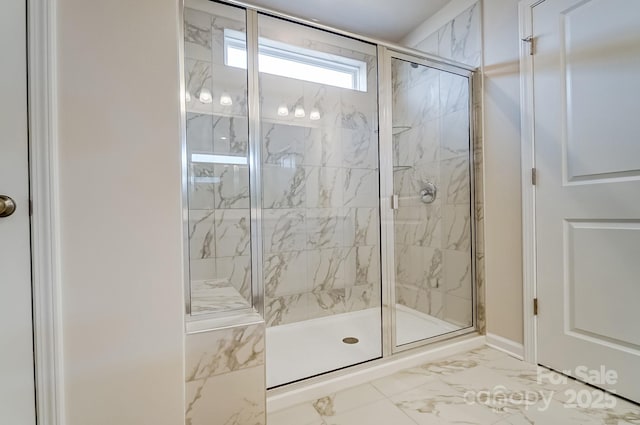 bathroom with baseboards, marble finish floor, and a stall shower