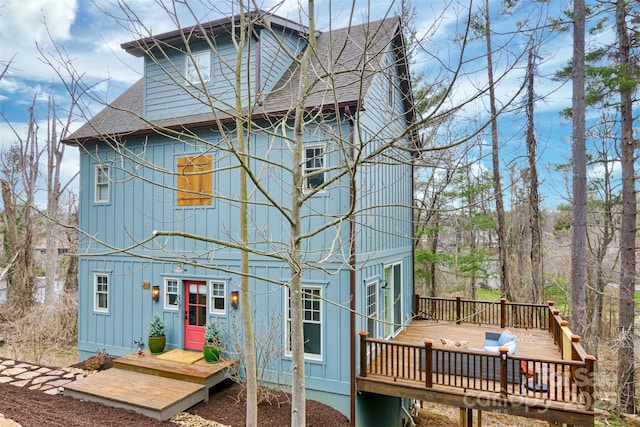 back of house with a wooden deck and roof with shingles