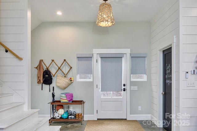 foyer entrance with stairway and baseboards