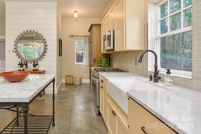 kitchen featuring tasteful backsplash, baseboards, concrete flooring, light stone counters, and stainless steel appliances