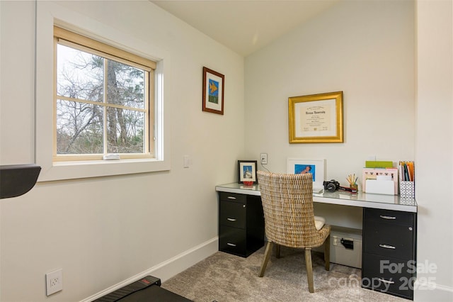 carpeted home office featuring baseboards and vaulted ceiling