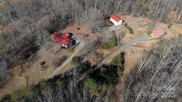 birds eye view of property featuring a forest view