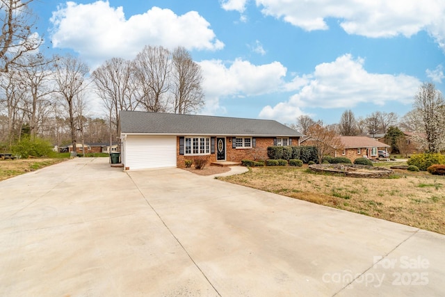 view of front of house featuring brick siding, concrete driveway, and a front yard