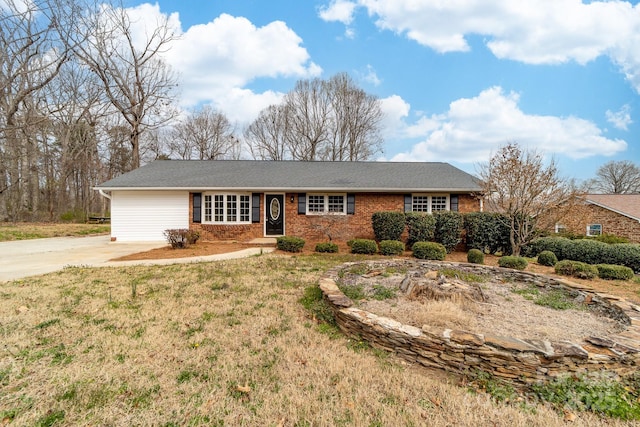 ranch-style house with brick siding, concrete driveway, and a front yard