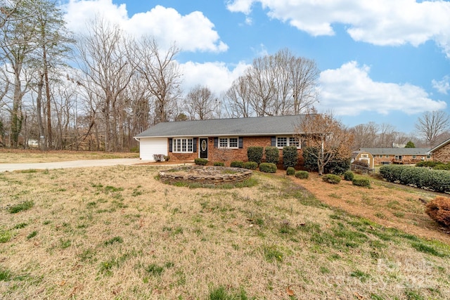 ranch-style home featuring driveway and a front yard