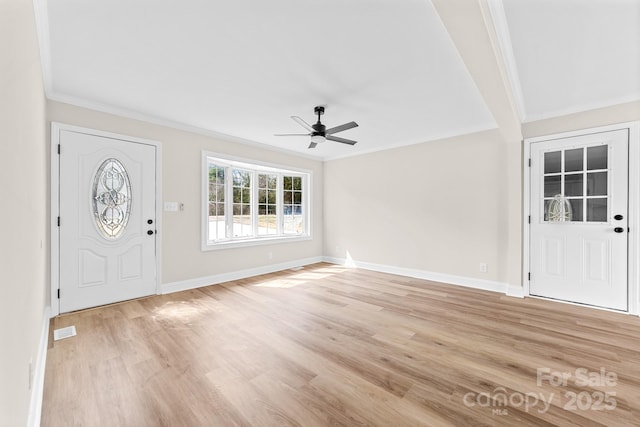 entrance foyer with light wood finished floors, baseboards, a ceiling fan, and ornamental molding