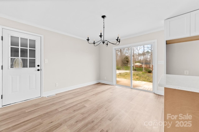 unfurnished dining area featuring a notable chandelier, crown molding, light wood-type flooring, and visible vents