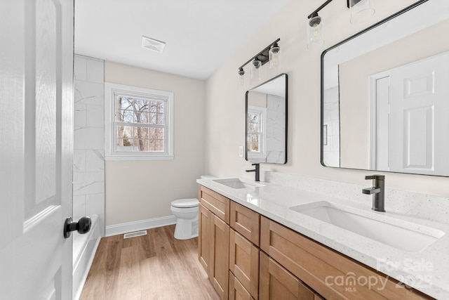 full bathroom featuring a sink, visible vents, toilet, and wood finished floors