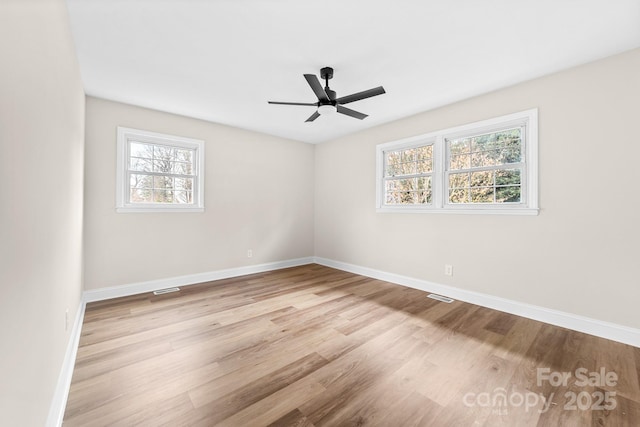 spare room with visible vents, baseboards, a ceiling fan, and wood finished floors