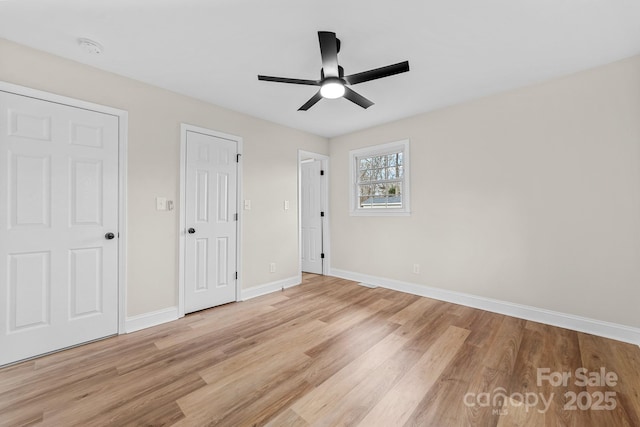 unfurnished bedroom with light wood-style floors, baseboards, and ceiling fan