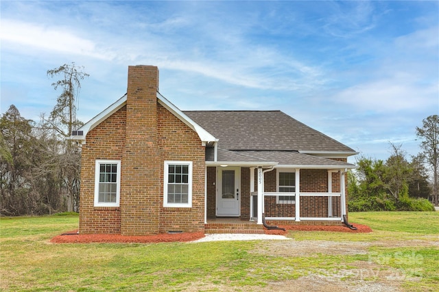 2005 Douglas Rd, Lancaster, SC 28720 - view of front of home featuring a front yard, a porch, a chimney, a shingled roof, and brick siding