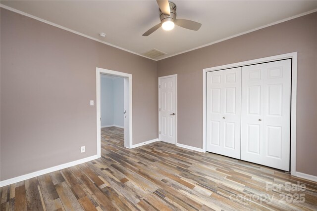 2005 Douglas Rd, Lancaster, SC 28720 - unfurnished bedroom featuring a closet, baseboards, wood finished floors, and crown molding