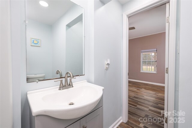2005 Douglas Rd, Lancaster, SC 28720 - half bath featuring vanity, baseboards, and wood finished floors