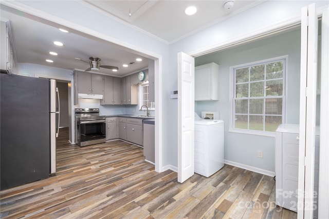2005 Douglas Rd, Lancaster, SC 28720 - kitchen with under cabinet range hood, a ceiling fan, appliances with stainless steel finishes, and washer / dryer