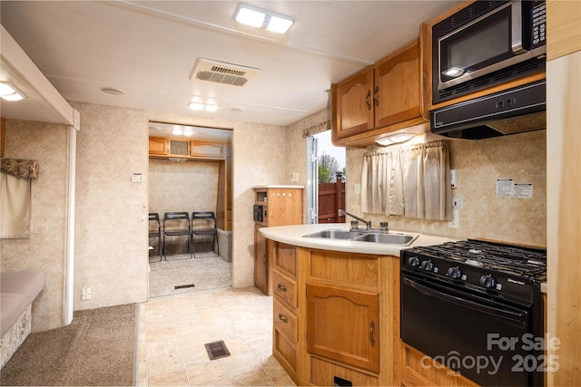 2005 Douglas Rd, Lancaster, SC 28720 - kitchen with visible vents, a sink, gas stove, brown cabinetry, and light countertops