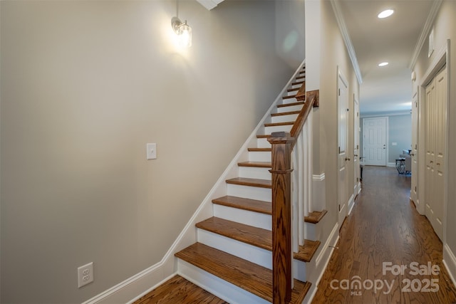 staircase featuring recessed lighting, crown molding, baseboards, and wood finished floors