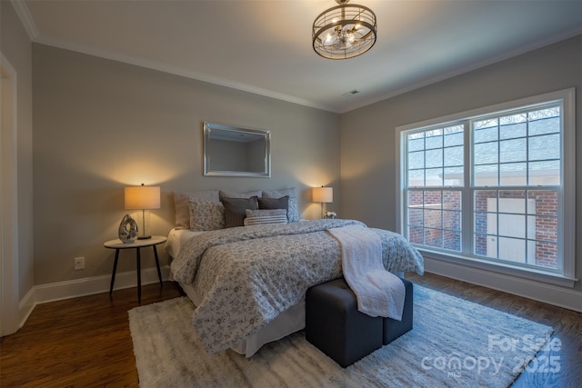 bedroom featuring ornamental molding, baseboards, and wood finished floors