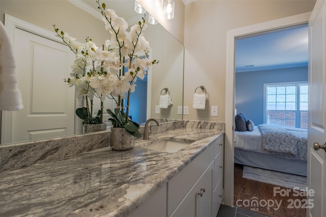 bathroom with wood finished floors, vanity, ensuite bath, and crown molding