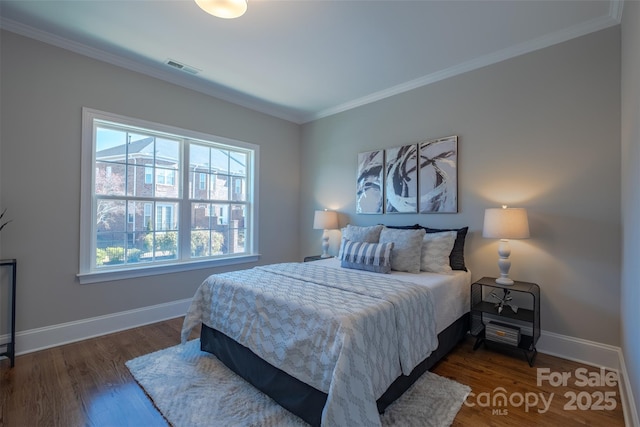 bedroom featuring visible vents, crown molding, baseboards, and wood finished floors