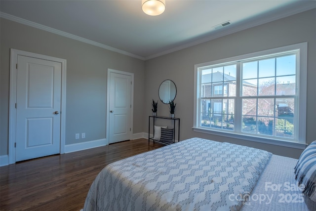 bedroom featuring dark wood-type flooring, crown molding, baseboards, and visible vents