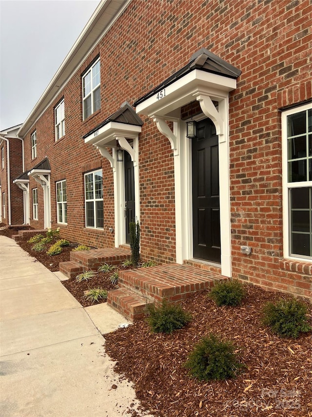 view of exterior entry featuring brick siding