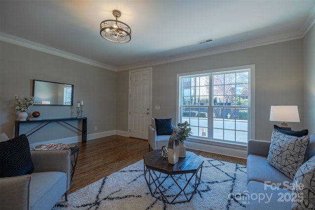 living room with visible vents, baseboards, wood finished floors, and ornamental molding