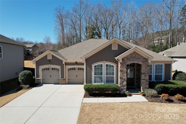 view of front of property featuring concrete driveway, an attached garage, stone siding, and roof with shingles