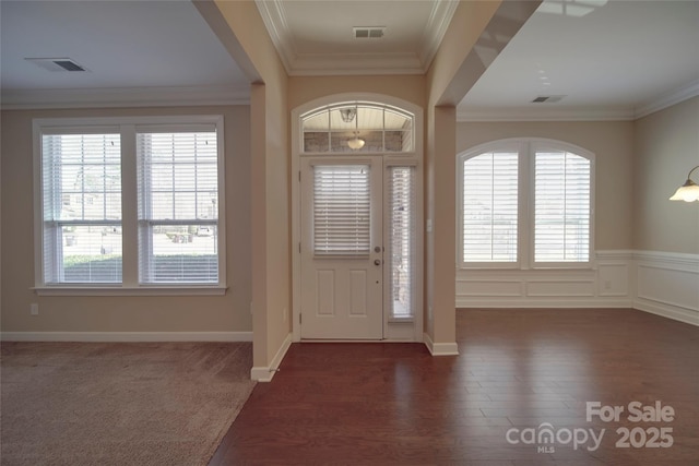 foyer entrance with visible vents, a healthy amount of sunlight, and ornamental molding