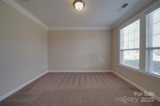 empty room featuring light colored carpet, crown molding, baseboards, and visible vents