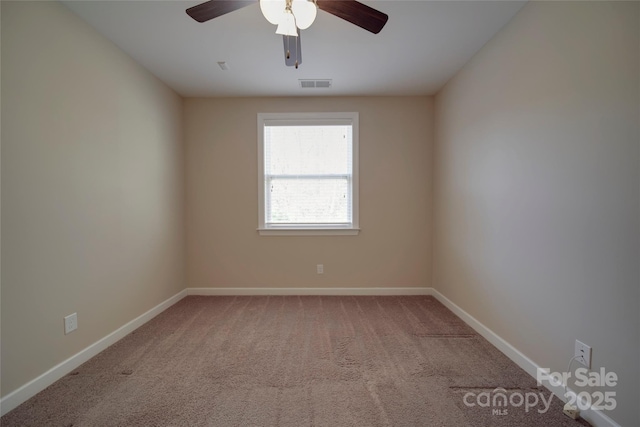 spare room with visible vents, baseboards, a ceiling fan, and carpet flooring