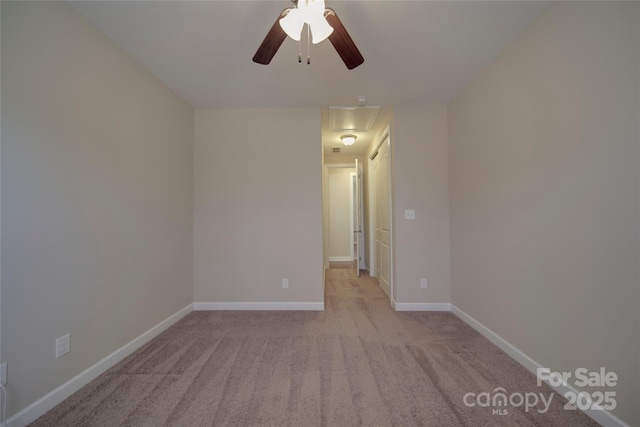 spare room with baseboards, light colored carpet, attic access, and ceiling fan