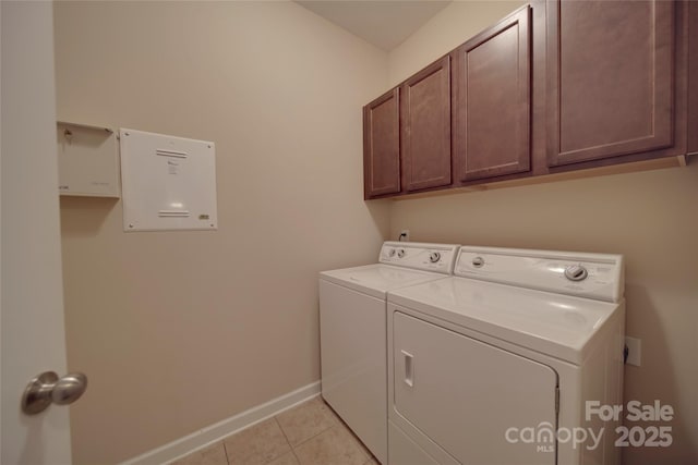 washroom featuring separate washer and dryer, light tile patterned flooring, cabinet space, and baseboards