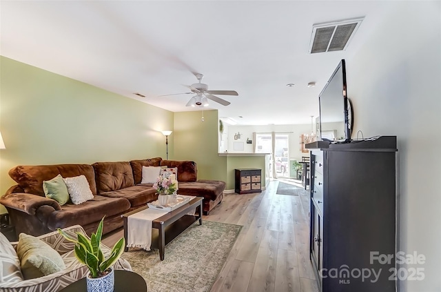 living area with visible vents, ceiling fan, and light wood finished floors