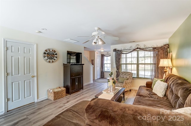 living area featuring visible vents, light wood-style floors, baseboards, and ceiling fan