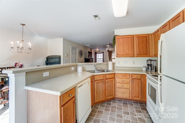 kitchen with visible vents, light countertops, a peninsula, white appliances, and a sink