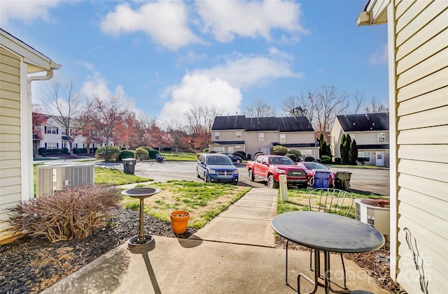 view of patio with a residential view and central AC unit