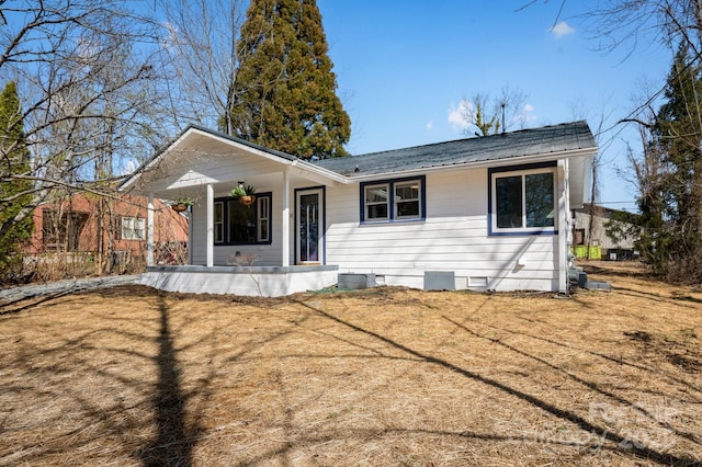 view of front of house featuring covered porch, metal roof, and a front yard