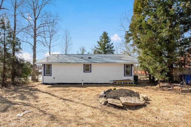 back of property featuring metal roof and fence