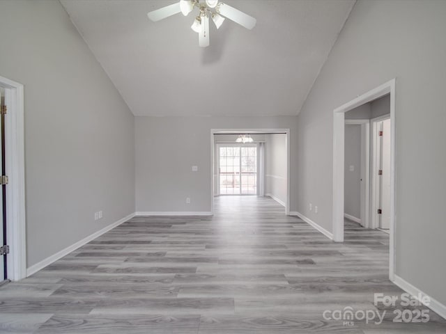 unfurnished room with light wood-type flooring, lofted ceiling, baseboards, and ceiling fan